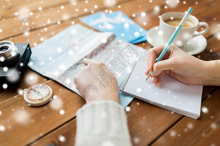 寒假,旅游,目的地人的旅行者的手与咖啡写笔记本上的雪图片