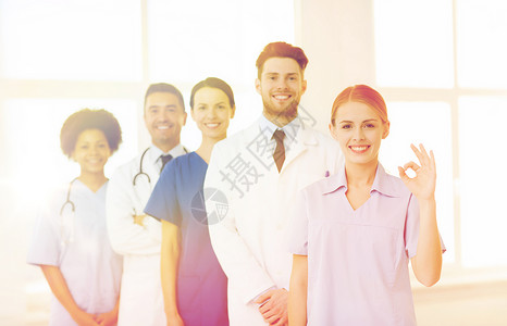 国际,专业,人医学的群快乐的医生护士医院OK手标志图片