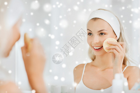 美丽,护肤人的微笑的轻女人发带洗她的脸与部清洁海绵浴室雪上背景图片