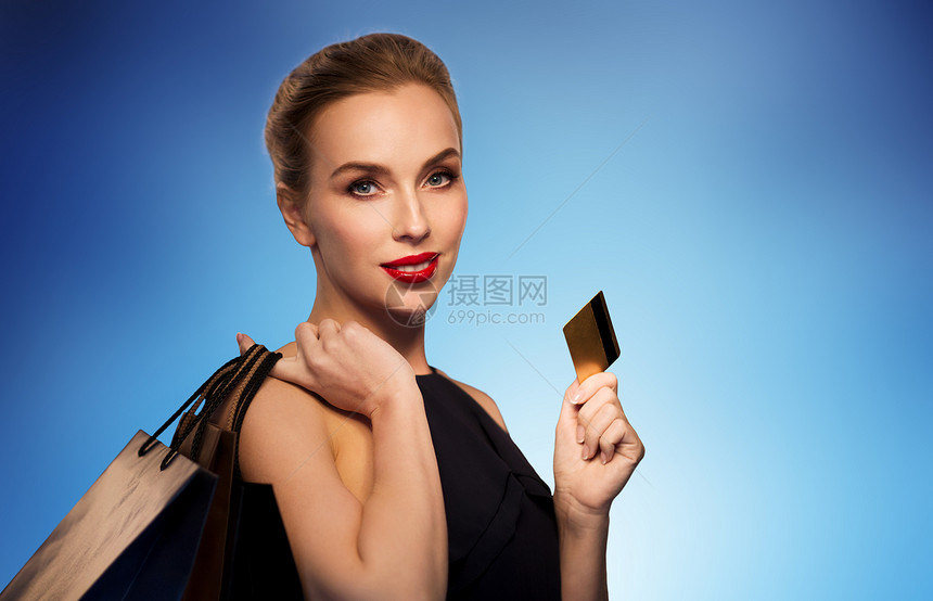 人,豪华销售美丽的女人与信用卡购物袋蓝色背景图片