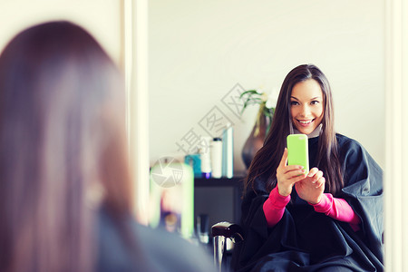 美容人的快乐的轻女人与智能手机采取镜子自拍发廊美发沙龙快乐的轻女人图片