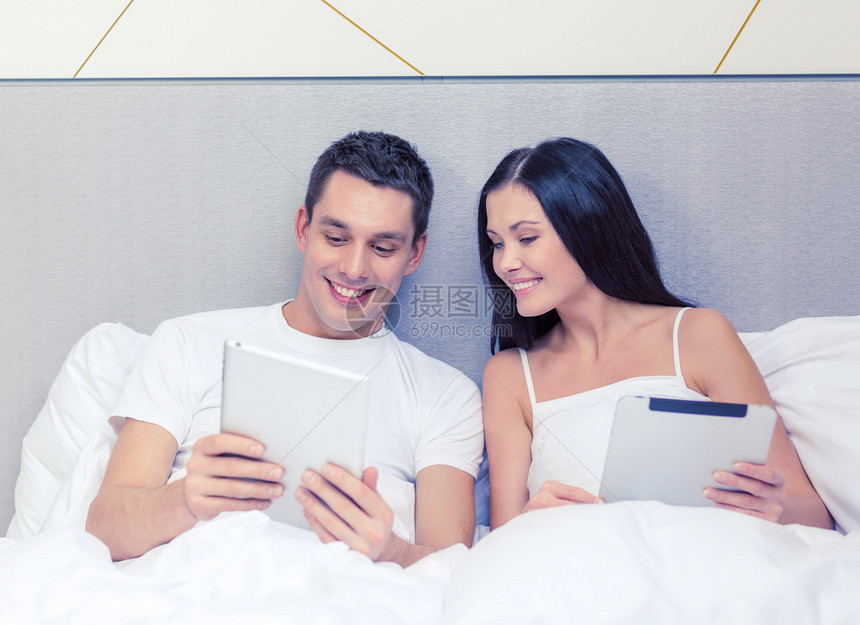 酒店,旅游,人际关系,技术,人际关系幸福的微笑的夫妇床上与平板电脑图片