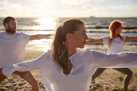 健身,运动,瑜伽健康的生活方式群人海滩上战士的姿势图片