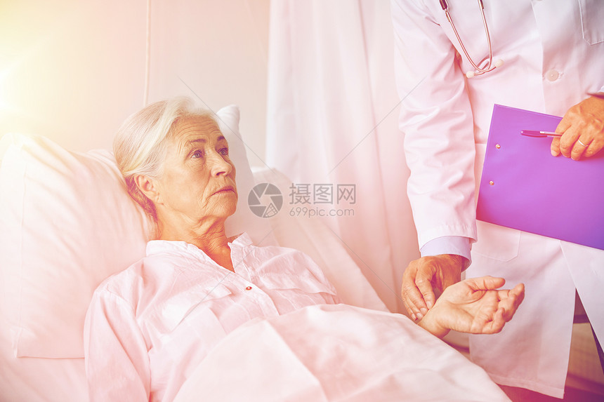 医学,龄,保健人的医生与剪贴板访问老病人妇女检查她的脉搏医院病房图片