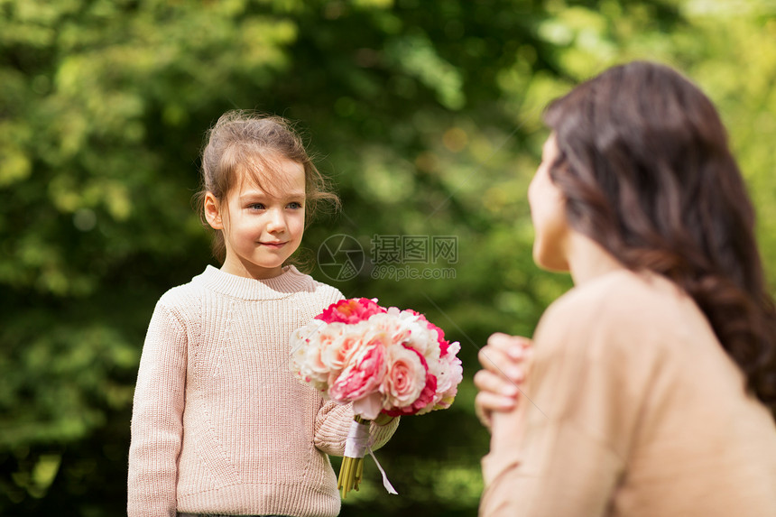 家庭,假期人的快乐的小女孩夏季公园给母亲送花图片