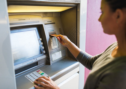借记金融,金钱,银行人的密切妇女插入卡自动取款机背景