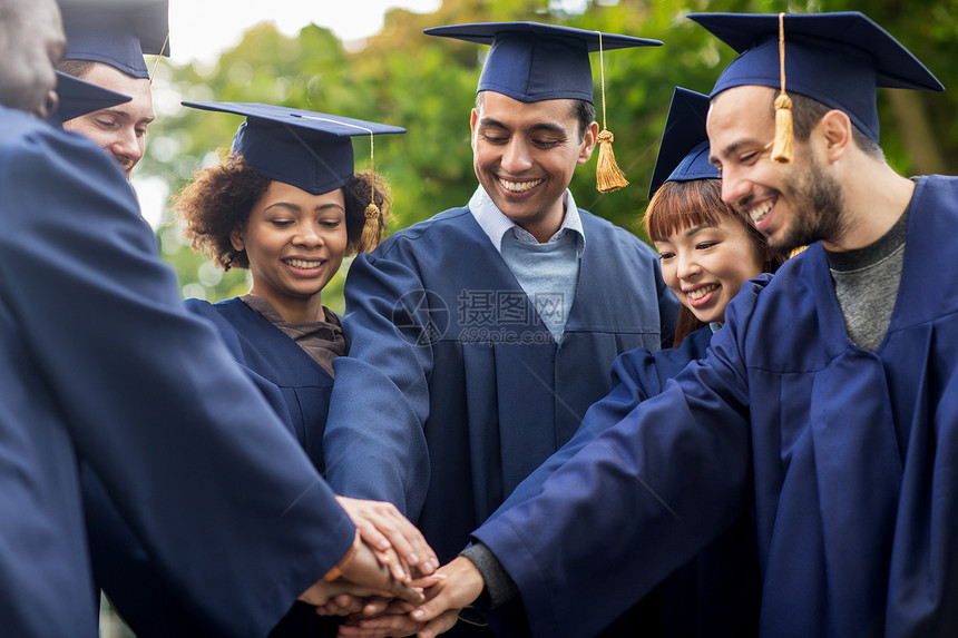 教育,毕业人的群快乐的国际学生砂浆板学士学位服把手放图片