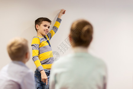 教育,小学,学人的快乐的学生男孩展示白色的墙壁图片