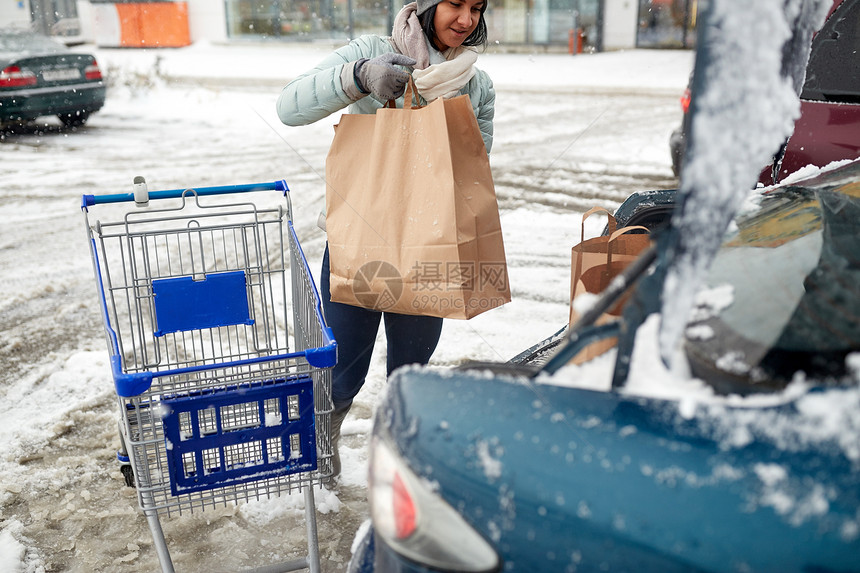 消费主义,交通人的妇女冬季停车时购物车汽车后备箱装载食物图片