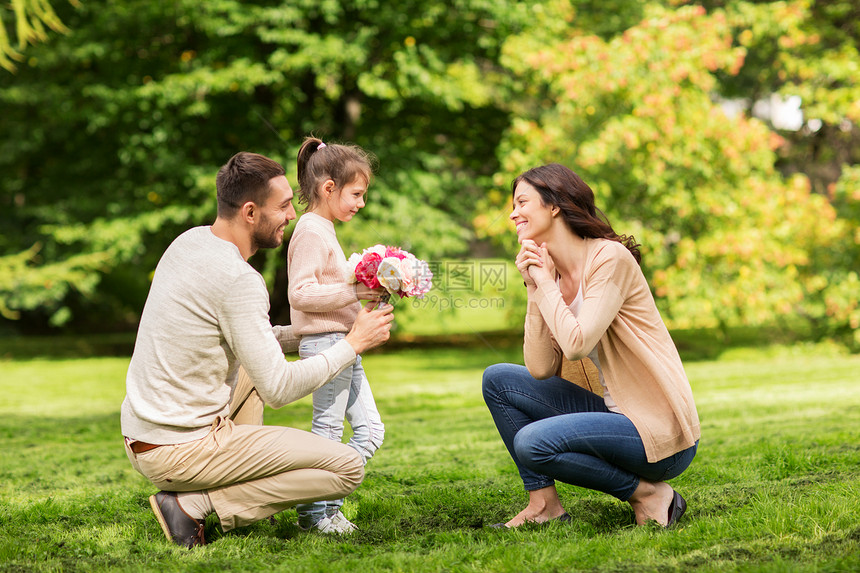 家庭,假期人的快乐的父亲小女孩夏季公园给母亲送花图片