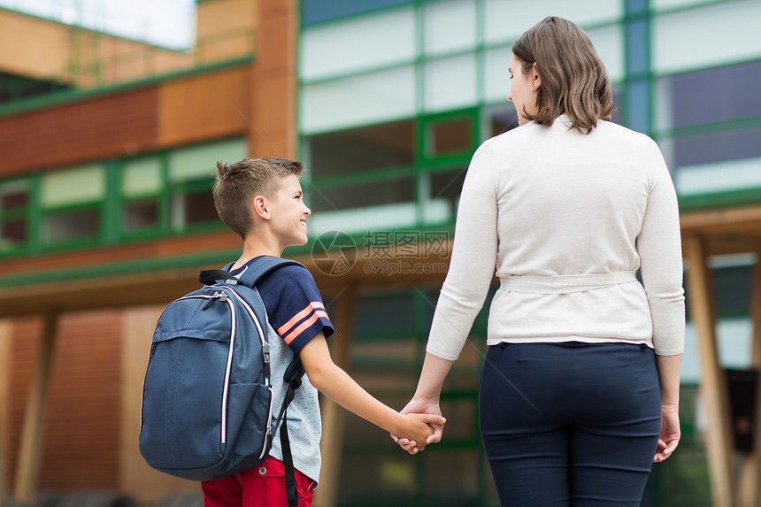 教育,童,家庭人的小学生男孩与母亲学校院子图片