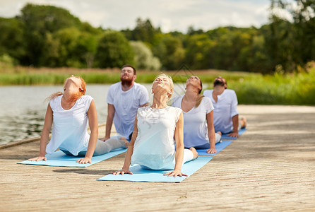 健身,运动,瑜伽健康的生活方式群人河流湖泊泊位上眼镜蛇姿势图片