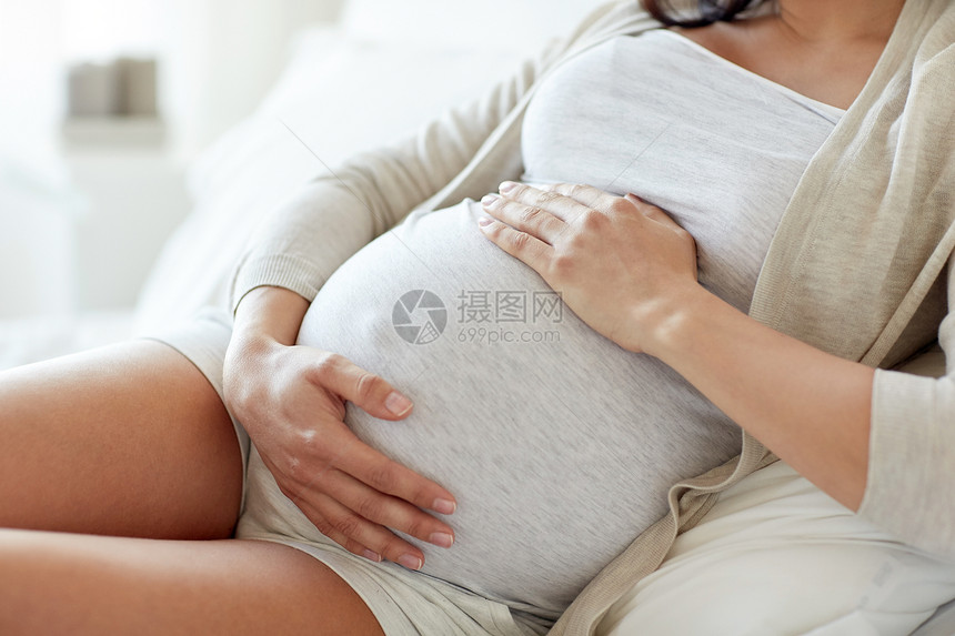 怀孕,休息,人期望密切孕妇躺床上,触摸她的肚子家里图片
