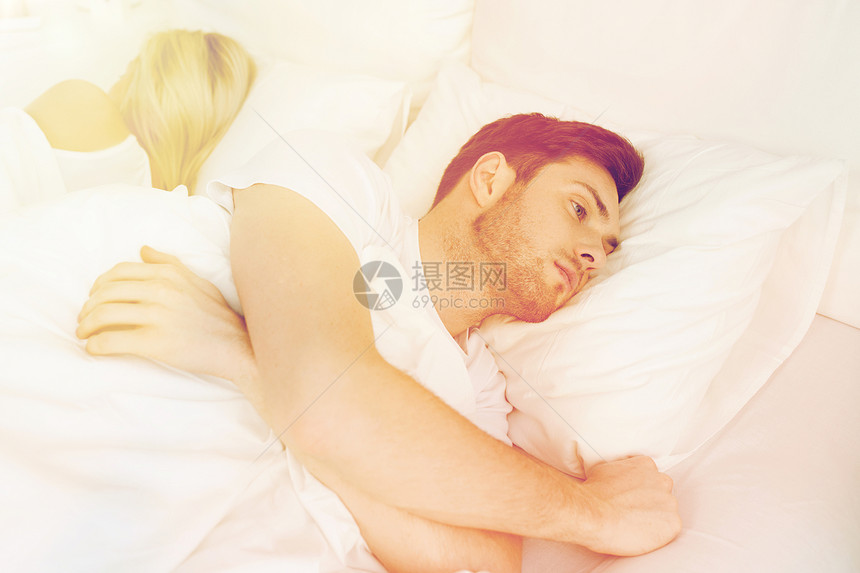 人,健康,睡眠障碍的夫妇背靠背躺家里的床上,轻人患失眠症图片