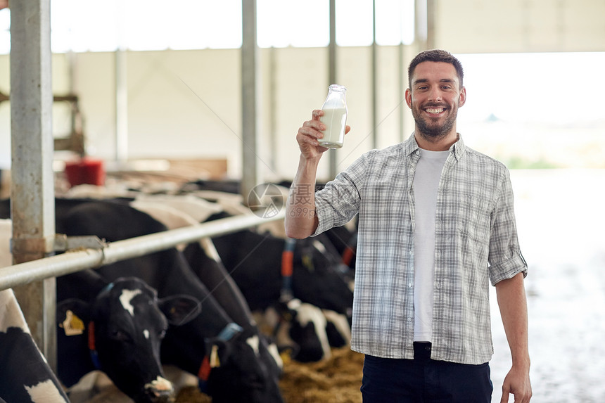 农业农业人民畜牧业快乐的轻人农民,奶牛场的牛舍里喝瓶牛奶图片