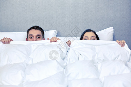 人,就寝时间,舒适关系幸福的夫妇躲床上的毯子下幸福的夫妇躲床上的毯子下图片
