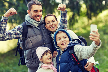 旅行,旅游,徒步旅行,技术人的快乐的家庭与背包采取自拍智能手机树林图片