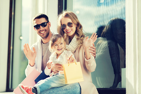 销售,消费主义人们的幸福的家庭与孩子购物袋挥手商店窗口城市图片