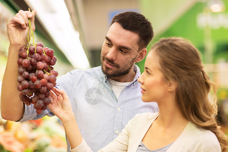 购物,食品,销售,消费主义人们的幸福的夫妇购买葡萄杂货店超市图片