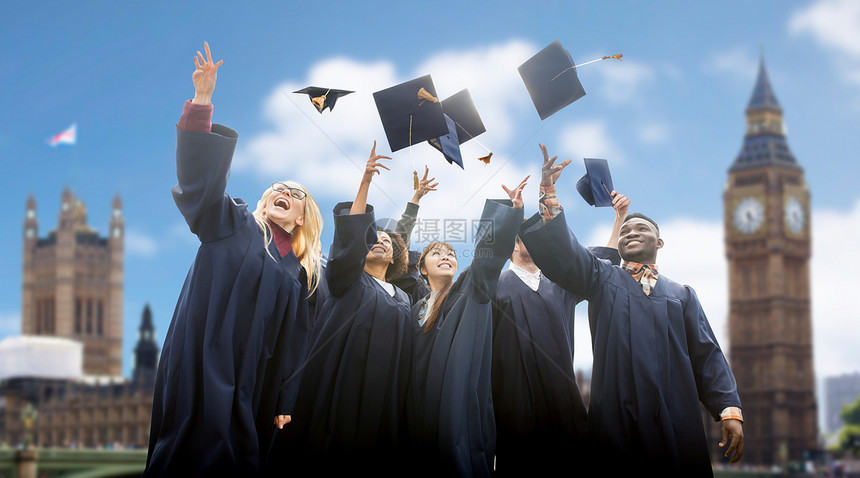 教育,毕业人的群快乐的国际学生穿着学士学位礼服,伦敦背景上扔沙板图片