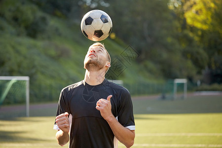 体育,足球人足球运动员球场上用头球技术玩杂耍球足球运动员球场上打球图片