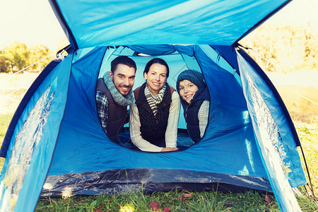 露营,旅游,徒步旅行人们的快乐的家庭帐篷内的营地图片
