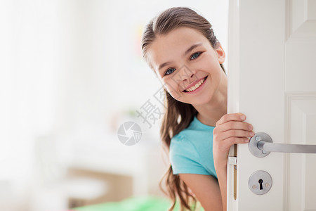 童,趣人的快乐的微笑美丽的女孩门后家图片