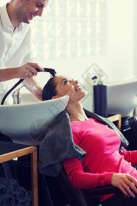 美容人的快乐的轻女人与理发师美发厅洗头美发沙龙快乐的轻女人背景图片