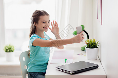 人,孩子技术女孩笔记本电脑智能手机自拍家里视频通话图片
