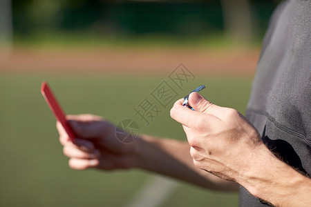 运动,谨慎,游戏人靠近裁判的手与哨子红牌足球场上图片