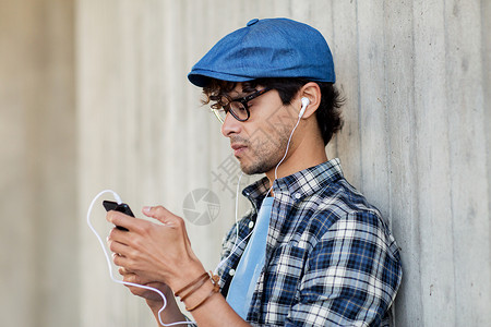 人,音乐,技术,休闲生活方式快乐的轻时尚男子戴着耳机智能手机听音乐图片