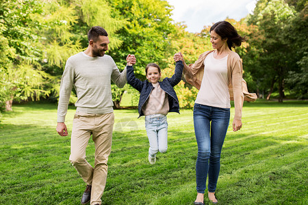 家庭父母收养人的快乐的母亲父亲小女孩夏季公园散步,玩得开心图片