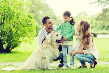 父亲与狗家庭,宠物,家畜人的快乐的家庭与拉布拉多猎犬夏季公园散步快乐的家庭与拉布拉多猎犬公园背景