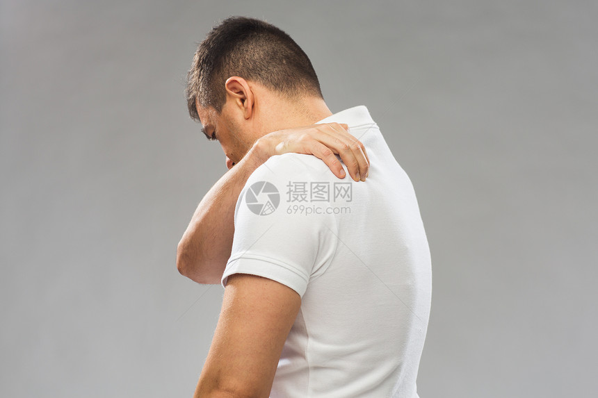 人,医疗保健问题密切的人遭受疼痛上背部灰色背景特写患背痛的人图片