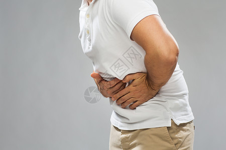 人保健健康问题的灰色背景下密切灰色背景密切关注患胃痛的人背景图片