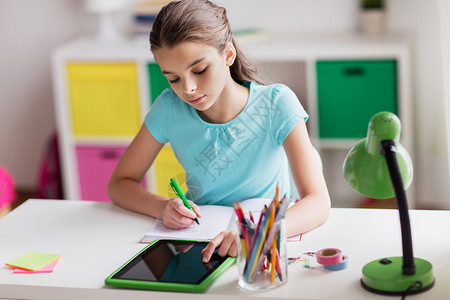 人,孩子,教育学女孩用平板电脑写笔记本家女孩家里用平板电脑写笔记本图片