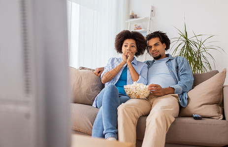 人,家庭休闲夫妇与爆米花家里看电视夫妇带着爆米花家看电视图片