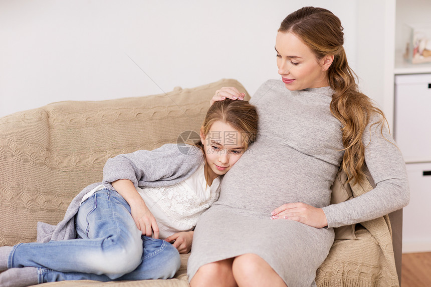 怀孕,人家庭观念快乐的孕妇女孩坐沙发上家家里沙发上快乐的孕妇女孩图片