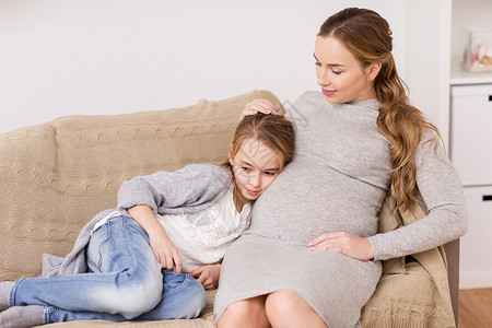 怀孕,人家庭观念快乐的孕妇女孩坐沙发上家家里沙发上快乐的孕妇女孩图片