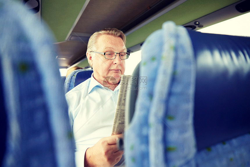交通,旅游,旅行人的老人阅读报纸旅游巴士快乐的老人旅行巴士上读报纸图片