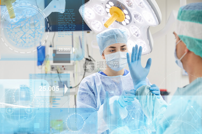 外科,医疗,医学人的护士协助外科医生帮助手套医院手术室与图表虚拟屏幕投影医院手术室的外科医生图片