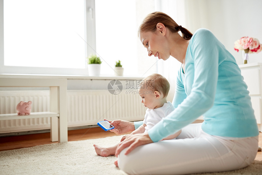 家庭,技术,孩子父母的快乐的微笑轻母亲向家里的小婴儿展示智能手机快乐的母亲家里给婴儿看智能手机图片