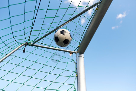 体育,足球比赛球飞足球球门网蓝天上足球空中飞进足球球门网图片