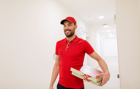 食物递送,邮件人的快乐的人送比萨饼纸箱走廊里披萨盒的快乐送货员图片