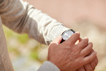 人的高级男子检查时间手表户外老人户外检查手表上的时间图片