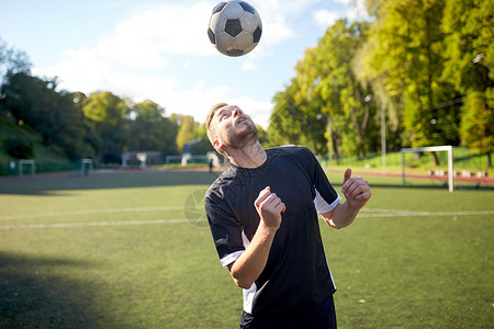 体育,足球人足球运动员球场上用头球技术玩杂耍球足球运动员球场上打球背景
