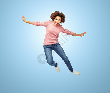 人,运动行动快乐的非裔美国轻妇女跳过蓝色背景快乐的非裔美国妇女跳过白色图片
