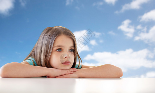 童,悲伤人的美丽的悲伤女孩蓝天云彩的背景蓝天白云上美丽的悲伤女孩图片