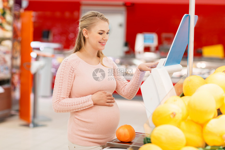 销售,购物,食物,怀孕人们的快乐的孕妇称重柚子杂货店超市孕妇杂货店里用柚子秤图片