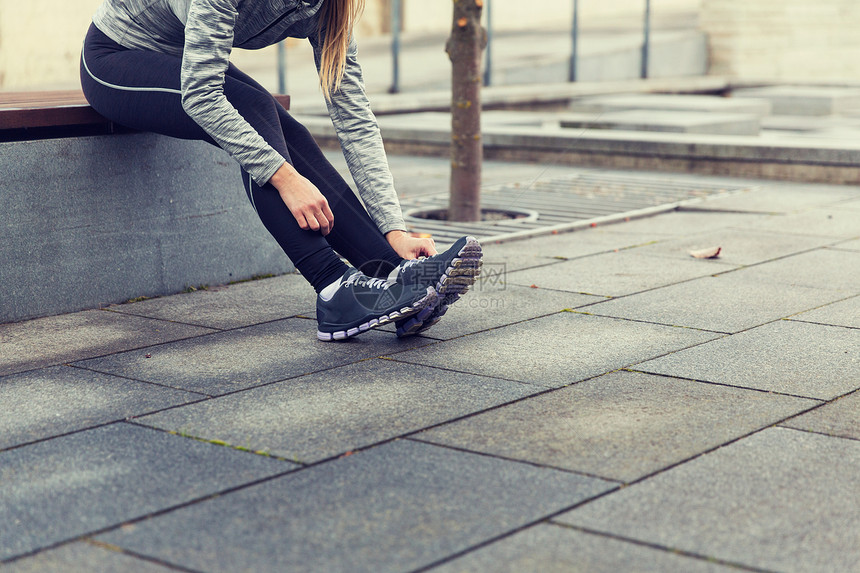 健身,运动,人生活方式的密切轻的运动女户外绑鞋靠近运动女人户外系鞋图片